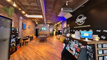 Un espace de détente moderne comprenant une table de billard, des sièges et un distributeur automatique.