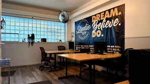 A modern office space with a large inspirational poster, a panoramic window, and a wooden desk. - STAY (Chicago)