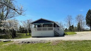 A small, single-story building with a covered porch and a staircase leading to an upper level. - A quiet retreat nestled right in the Hoosier National Forest. (Saint Croix)