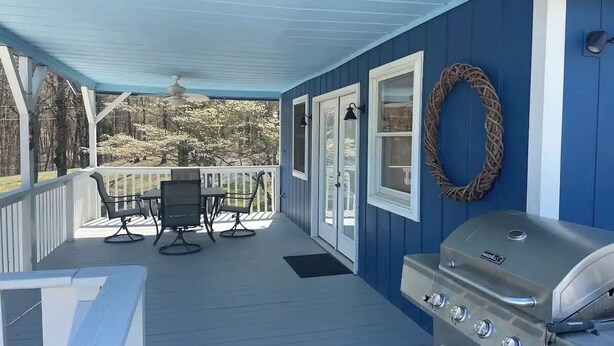 A covered porch with a grill, outdoor furniture, and a view of trees. - A quiet retreat nestled right in the Hoosier National Forest. (Saint Croix)