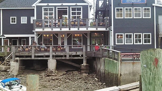 A two-story building with a balcony and a sign that reads "SEAFOOD RESTAURANT".