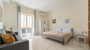 Una habitación de hotel con una cama, un sofá, una mesita y un banco.