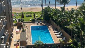 A rooftop pool with a view of the beach and palm trees. - Top Floor Beachfront Condo with Ocean view (Kihei)