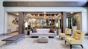 A spacious living area with a sofa, armchairs, and a coffee table. A large window provides natural light, and the room features a modern design with a neutral color palette. - King Beds-Walk Score 81 & Parking 3047 (Scottsdale)