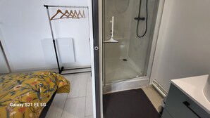 A small, modern room with a bed, a shower area, and a white radiator. - Proche Centre Ville, Appartement Pour 6 Voyageurs Comprenant 3 Suites (Châlons-en-Champagne)