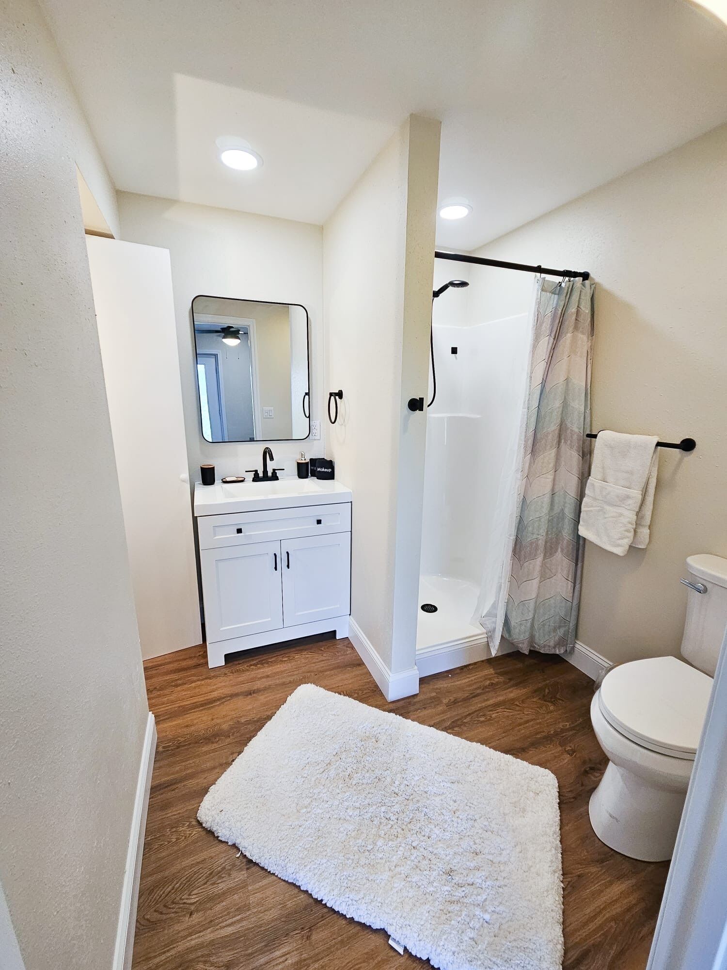 A bathroom with a shower, toilet, and sink.