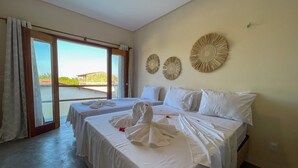 Una habitació d'hotel amb dos llits, una finestra gran amb cortines i decoració mural.