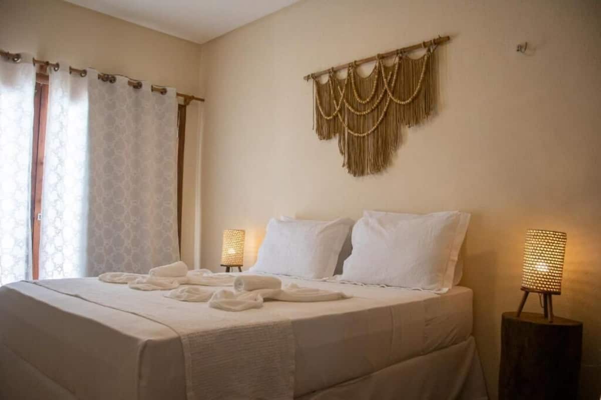 Ein Hotelzimmer mit einem großen Bett, zwei Nachttischlampen und einem dekorativen Wandbild.