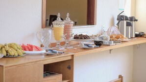 Buffet de l'esmorzar amb diferents plats i una cafetera.