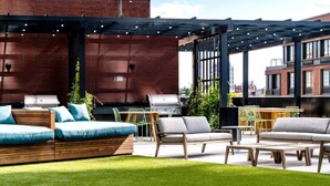 An outdoor seating area with a grill, cushioned seating, and a pergola with string lights. - Gorgeous apt for Labor Day weekend.  View of Manhattan at Greenpoint 



 (Brooklyn)