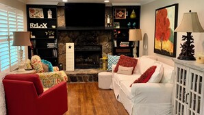 A living room with a fireplace, a red armchair, a white sofa, and a bookshelf. - 3 LITTLE BEARS DEN AT BEAR PAW
GREAT FAMILY VACATION HOME. EVERYTHING YOU NEED (Murphy)