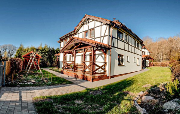 A two-story house with a balcony, a wooden structure, and a well-maintained garden. - 3 bedroom beach front home in Debina (Debina)