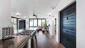 A modern kitchen with a central island, built-in appliances, and a ceiling fan. - Stunning Ocean Views; 2 Pools;10 min walk to beach (Sayulita)