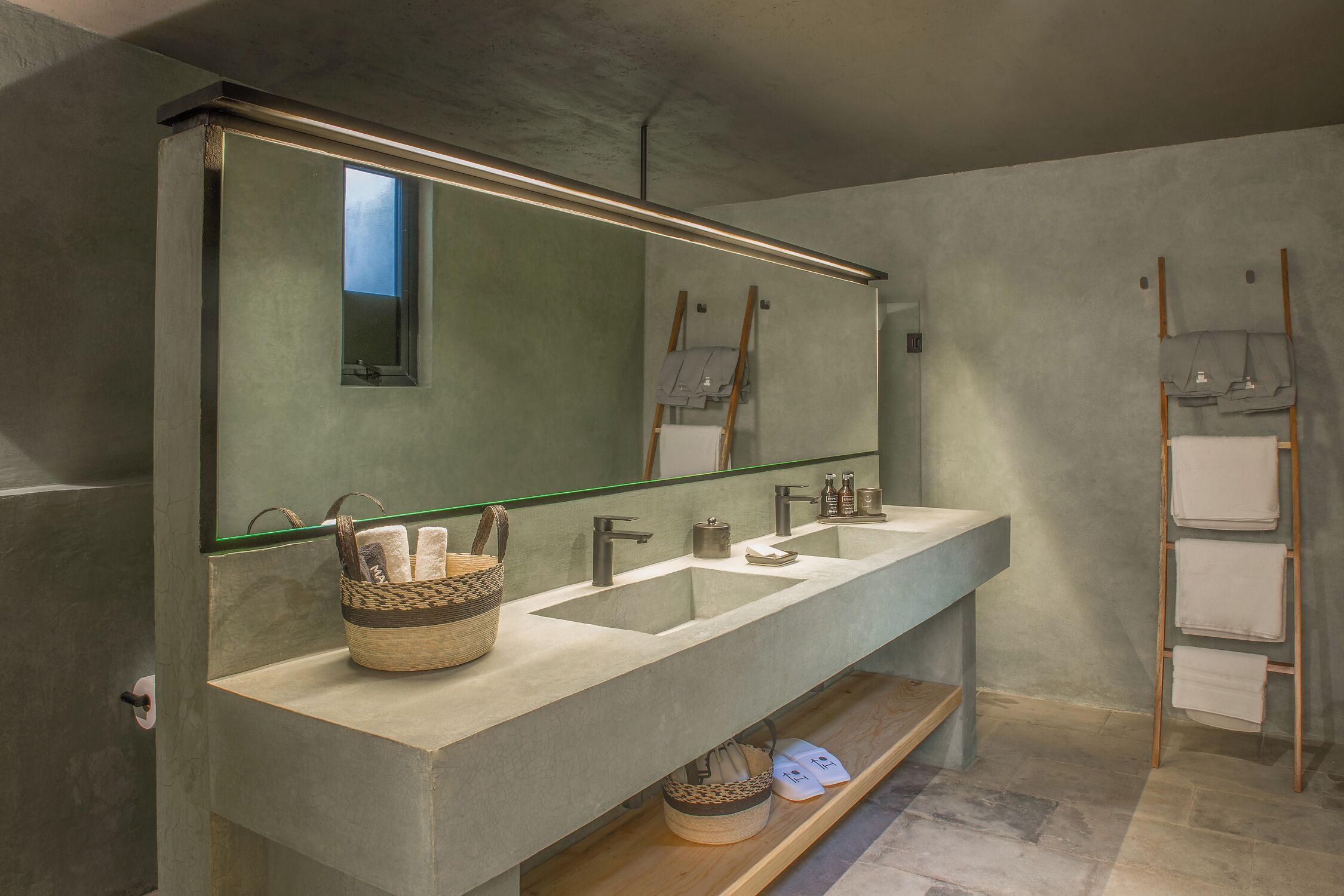 A modern bathroom with a large mirror, two sinks, and a wooden shelf.