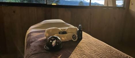 A wooden bed with a patterned bedspread and a toy car and motorcycle on it.