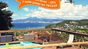 A pool area with lounge chairs and a hot tub, overlooking a coastal town and the sea. - Vue mer Imprenable ! F2 2/4 Pers, Jacuzzi Privatif et Piscine Privée (Les Trois-Îlets)