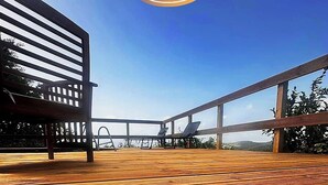 A wooden deck with a view of the sea, a lounge chair, and a sunbed. - Vue mer Imprenable ! F2 2/4 Pers, Jacuzzi Privatif et Piscine Privée (Les Trois-Îlets)