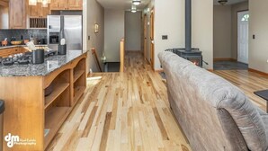 A modern kitchen with wooden cabinets, a stainless steel refrigerator, and a granite countertop. - Fleur de Lis 4bed 3bath & Mountain Views (Wasilla)