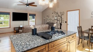A kitchen with granite countertops, wooden cabinets, a built-in stove, and a ceiling fan. - Fleur de Lis 4bed 3bath & Mountain Views (Wasilla)