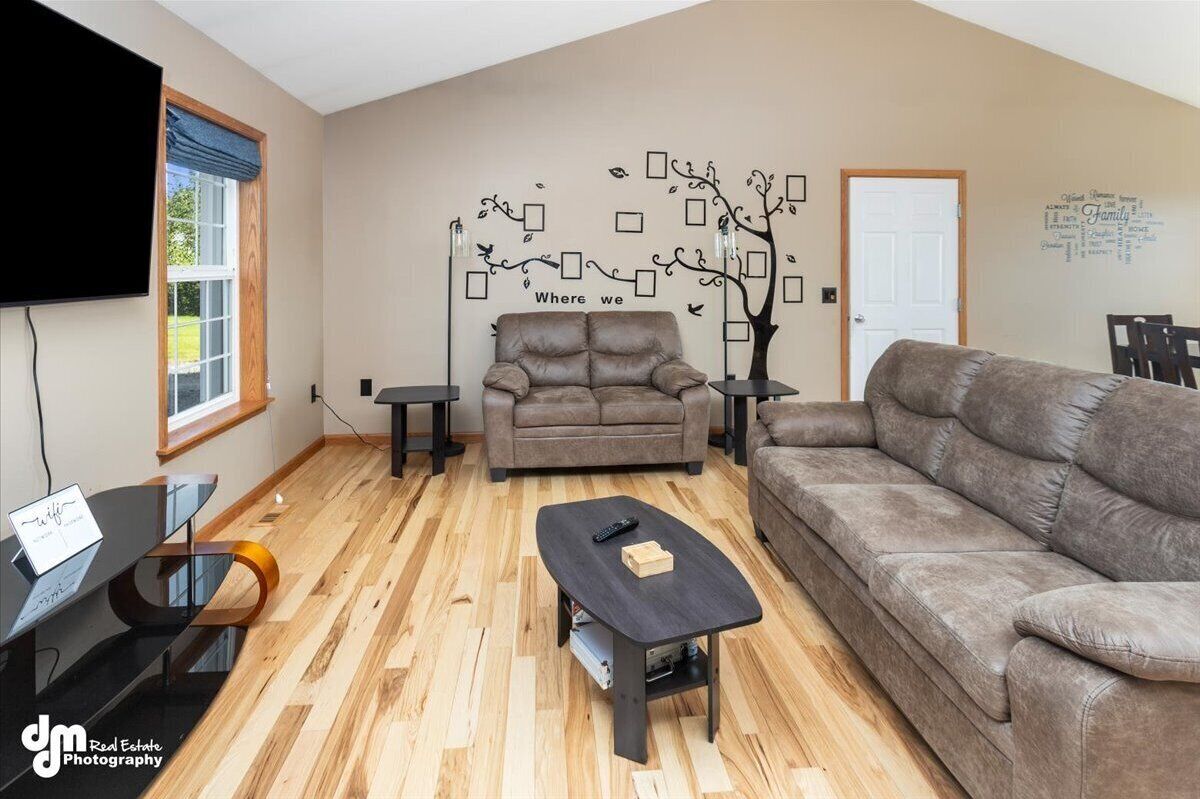 A living room with two sofas, a coffee table, a TV, and a wall decoration.
