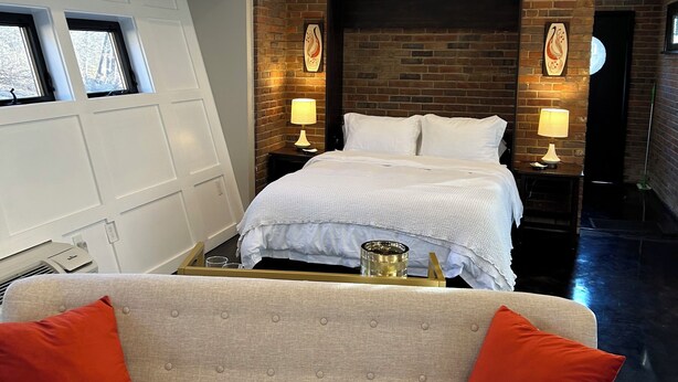 Une chambre moderne avec un grand lit, un canapé et un design de plafond original.