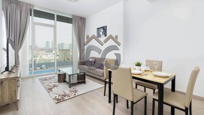 Uma sala de estar moderna com uma mesa de jantar de vidro, sofá e vista para a cidade.