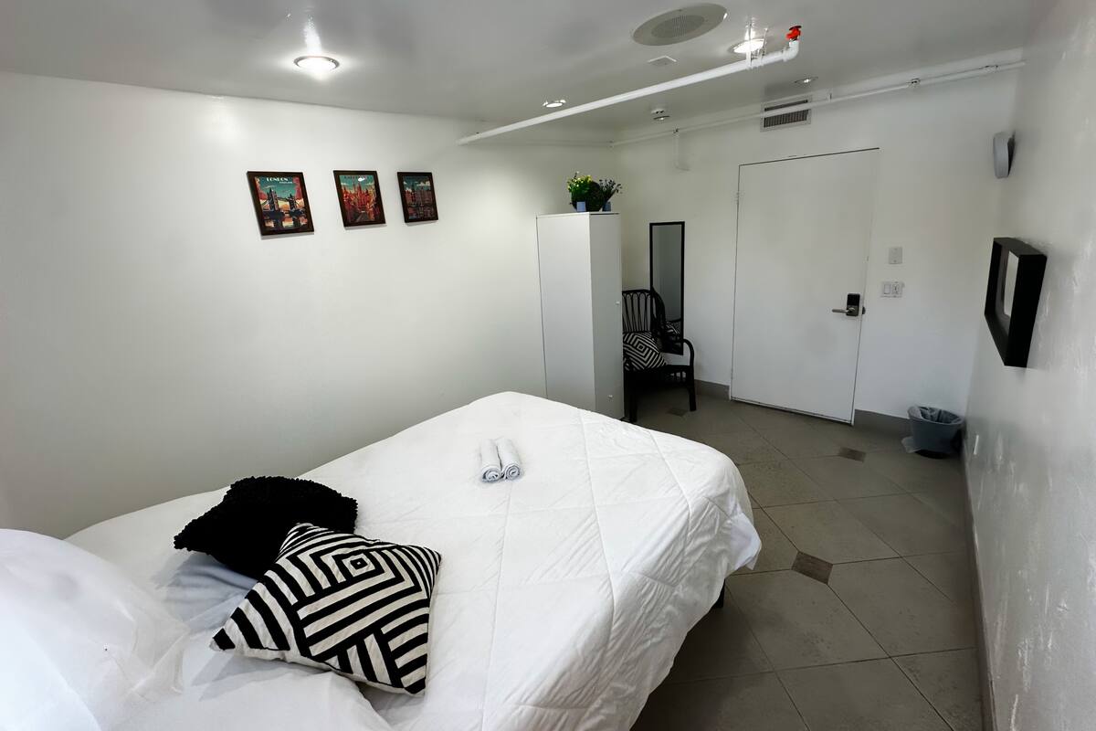 Ein Hotelzimmer mit einem Bett, einem Sessel, einem Kleiderschrank und einer Tür.