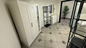 A modern bathroom with a white wardrobe, a glass shelf unit, and a sink. - Culver City Hostel (Culver City)