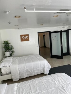 Ein modernes Hotelzimmer mit einem Bett, einer Topfpflanze und einer Weltkarte an der Wand.