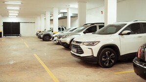 Un parcheggio sotterraneo con diversi SUV bianchi parcheggiati uno accanto all'altro.