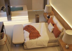 A modern hotel room with a large bed, a small table, a bench, a bathtub, and a bedside table with a lamp. - Roma Hotel by H Hotéis - Airport (Arniqueiras)