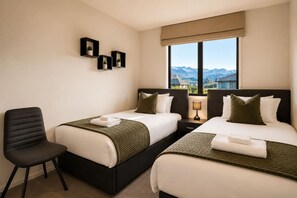 A hotel room with two beds, a chair, a window with a mountain view, and three wall-mounted shelves with plants. - Remarkable Mountain Scene - A Modern Escape (Jacks Point)