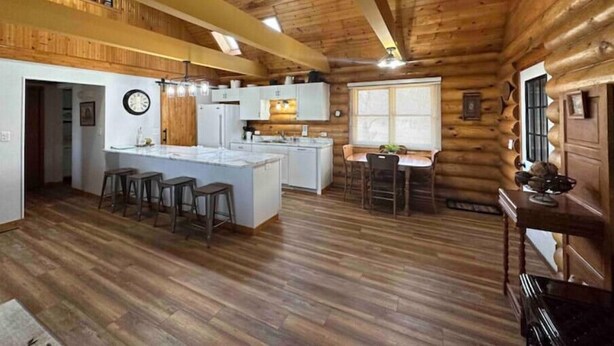 L’intérieur d’une cabane en rondins comprend une cuisine, un coin repas et un bar.