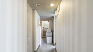 Un pasillo estrecho y bien iluminado con una escalera al final, que da a una plataforma.