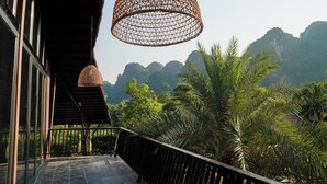 A balcony with a view of mountains and palm trees. - Tam Coc Retreat Ninh Bình (Nam Hoa Lu)