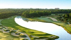 A golf course with a winding water feature and a path. - Stunning and Clean Hidden Gem w/ 2 Pools Beach Golf & Shops in Barefoot (North Myrtle Beach)