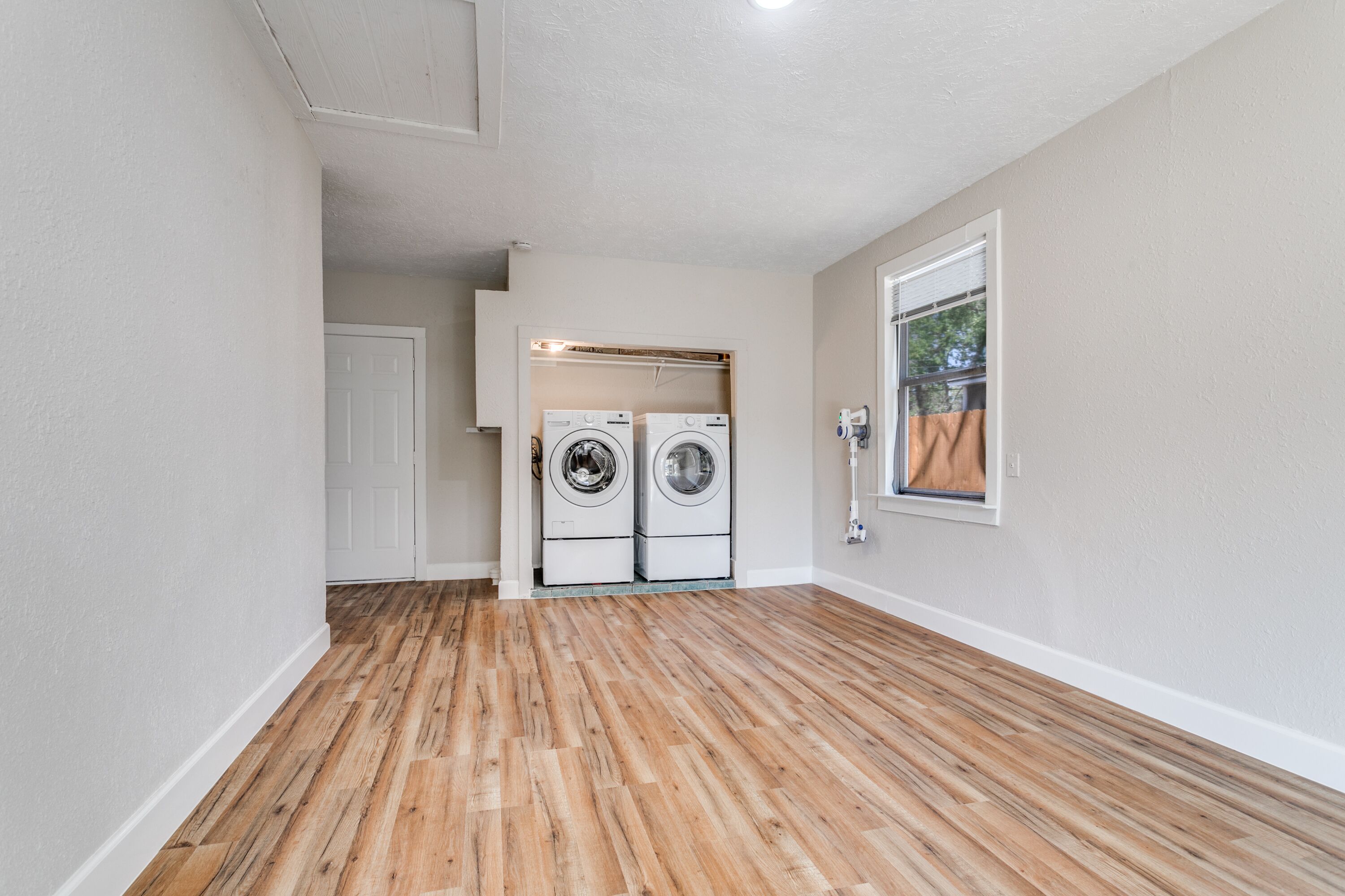 A laundry room with two washing machines and a window.