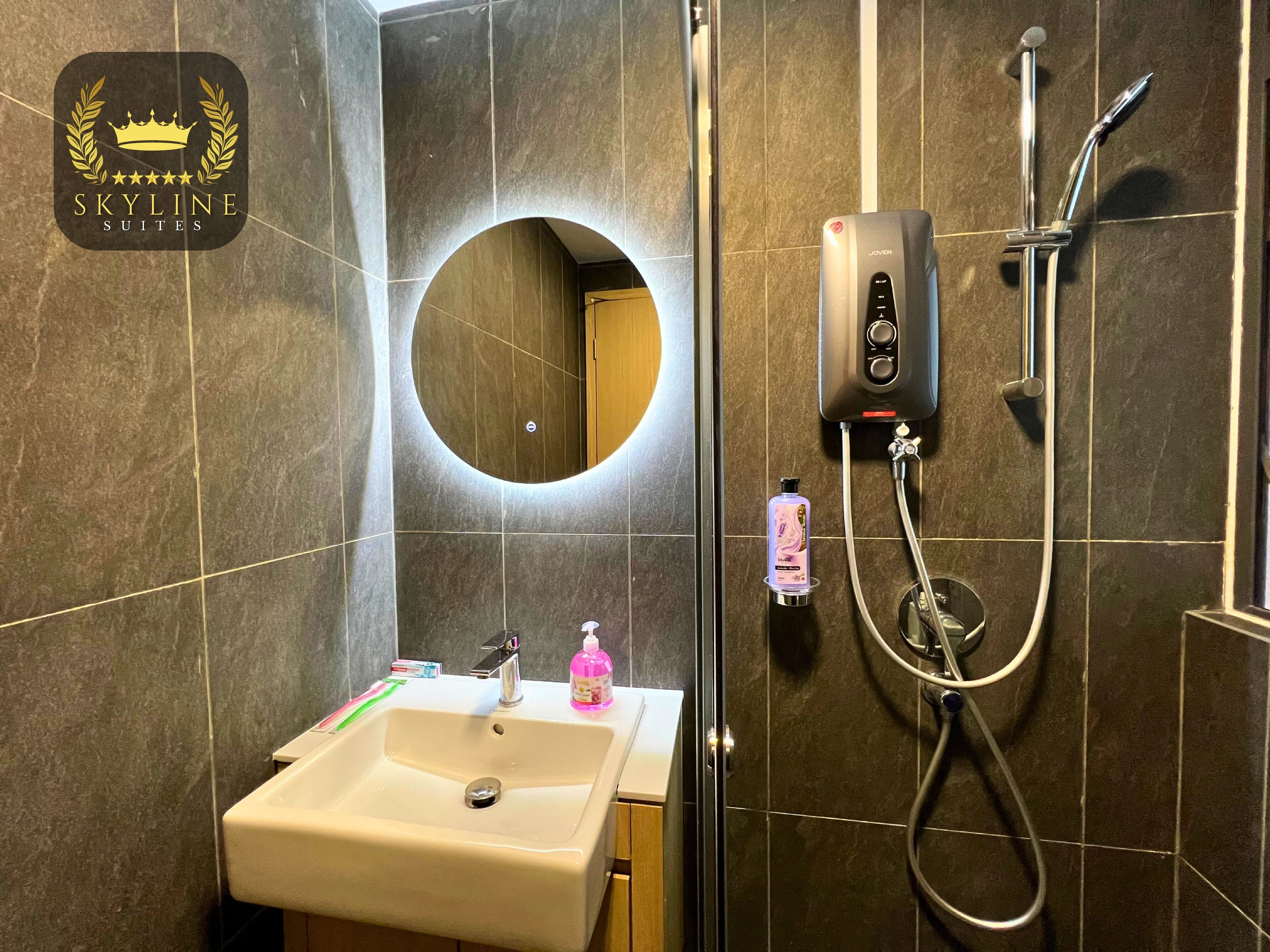 Un baño con lavamanos, espejo y ducha.