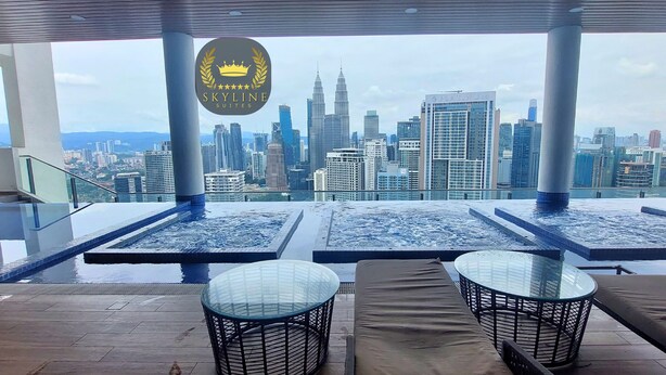 A rooftop pool area with glass tables and lounge chairs, overlooking a city skyline. - The Colony Skyline Suites KLCC (Kuala Lumpur)