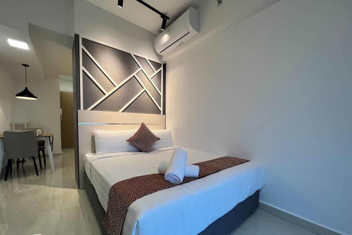 Une chambre d’hôtel moderne, dotée d’un grand lit, d’un bureau et d’une chaise.