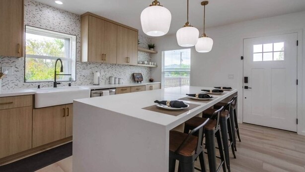 A modern kitchen with a large island, wooden cabinets, and pendant lighting. - Home with views close to all attractions San Diego (Escondido)