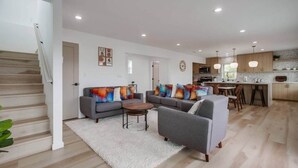 A modern living room with a grey sofa set, a coffee table, and a staircase. - Home with views close to all attractions San Diego (Escondido)