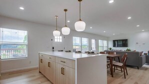 A spacious kitchen with a large island, wooden cabinets, and pendant lighting. - Home with views close to all attractions San Diego (Escondido)