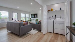 A modern living room with a grey sofa, a coffee table, and a TV mounted on the wall. - Home with views close to all attractions San Diego (Escondido)