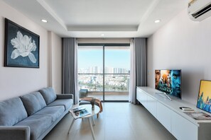 Deluxe Apartment | Living area | 50-inch Smart TV with cable channels, Netflix, streaming services - Gold View Saigon Riverside (Ho Chi Minh City)