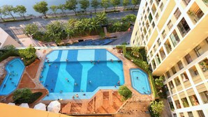 A rooftop pool area with multiple swimming pools and surrounding greenery. - Gold View Saigon Riverside (Ho Chi Minh City)