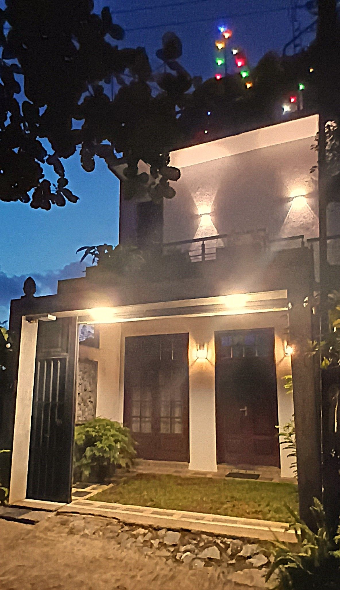 A two-story building with a front entrance, a small porch, and a visible door.