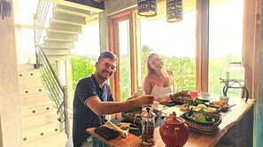 Ein Essbereich mit Treppe, einem Couchtisch mit Teekanne und Blick ins Grüne.