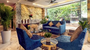 Ein modernes Wohnzimmer mit einem blauen Sofa, einem Couchtisch und einer Wand aus Stein.