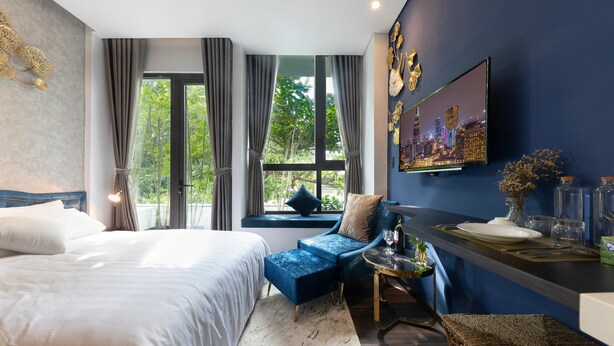 Ein modernes Hotelzimmer mit einem großen Bett, einem blauen Sofa, einer Essecke und einem Stadtbild an der Wand.